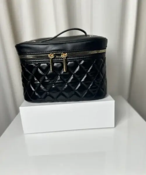 Black quilted makeup case with gold zippers.