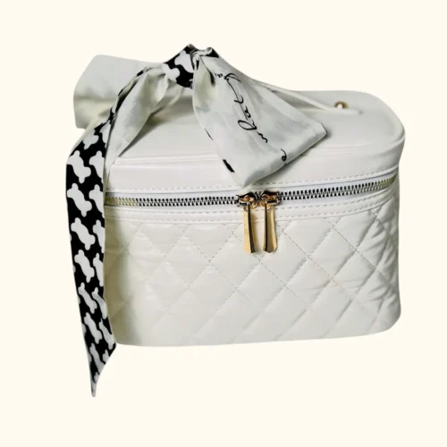 White quilted cosmetic case with ribbon.