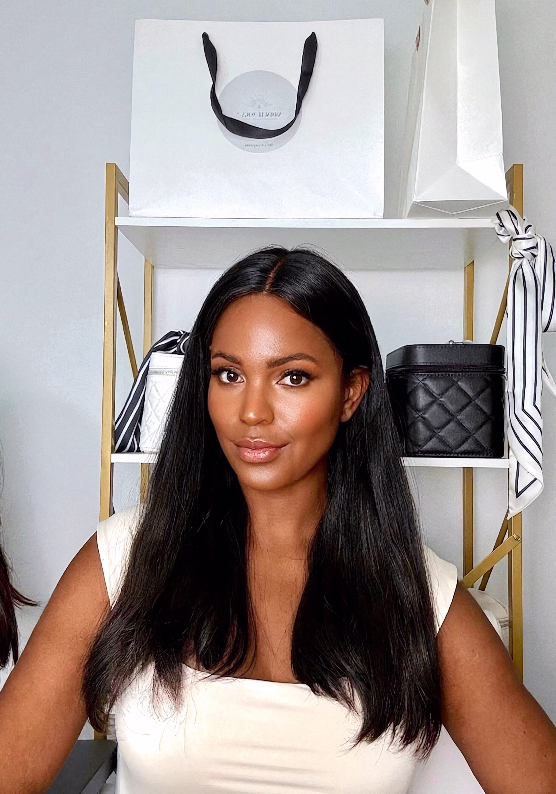 Woman with long black hair, smiling.