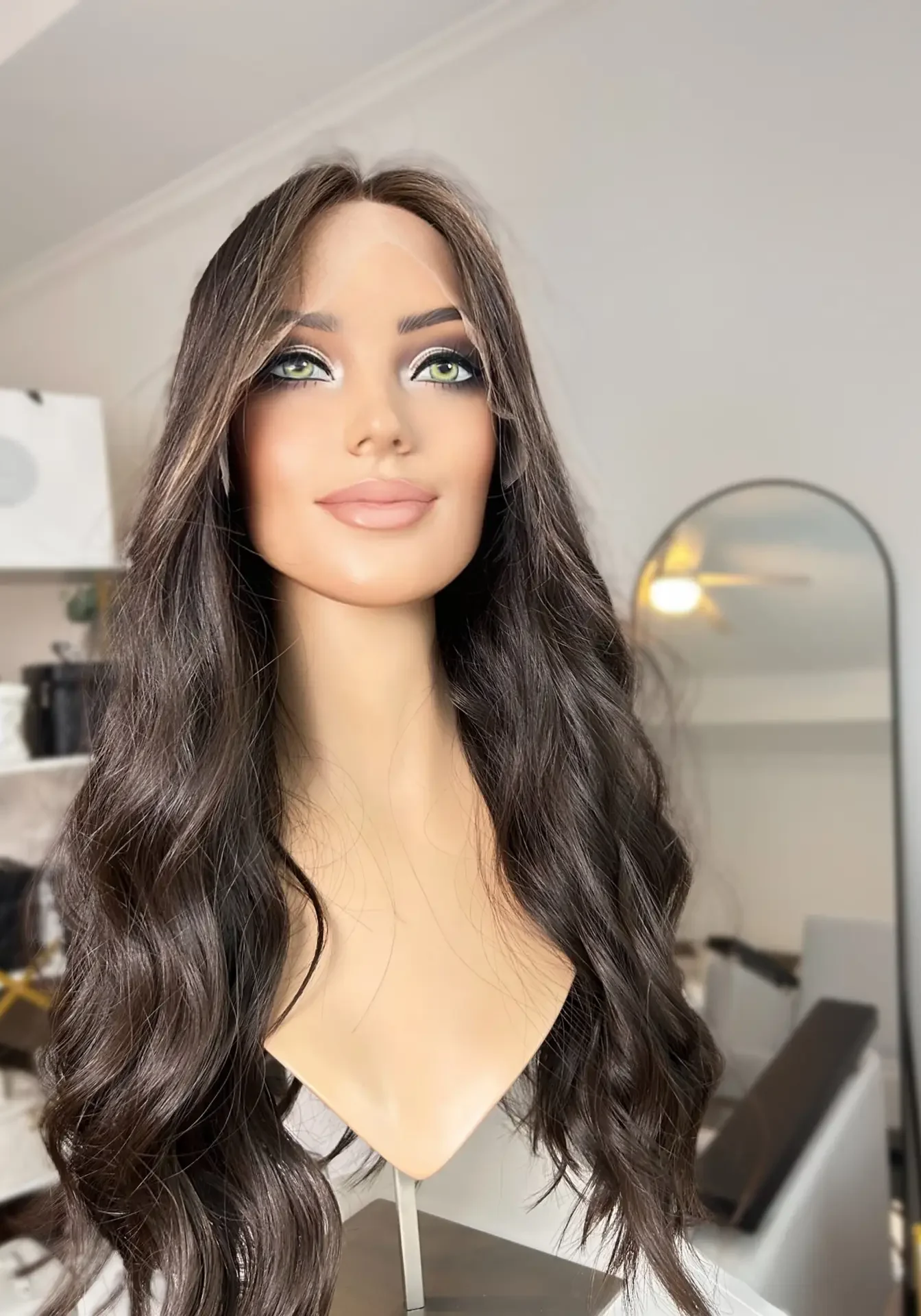 Woman modeling long, wavy brown hair wig.