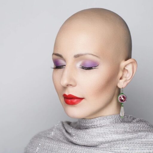 Bald person with purple eyeshadow and red lipstick